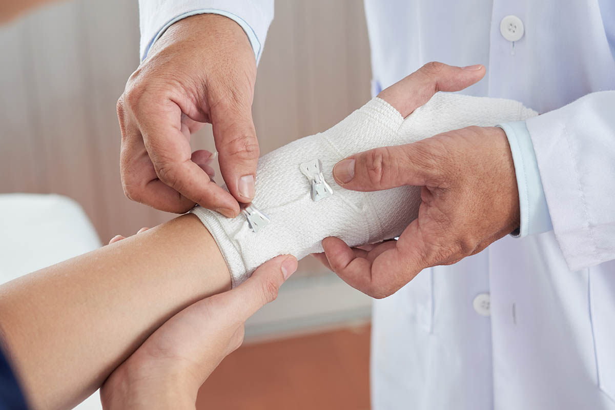Doctor bandaging patients hand