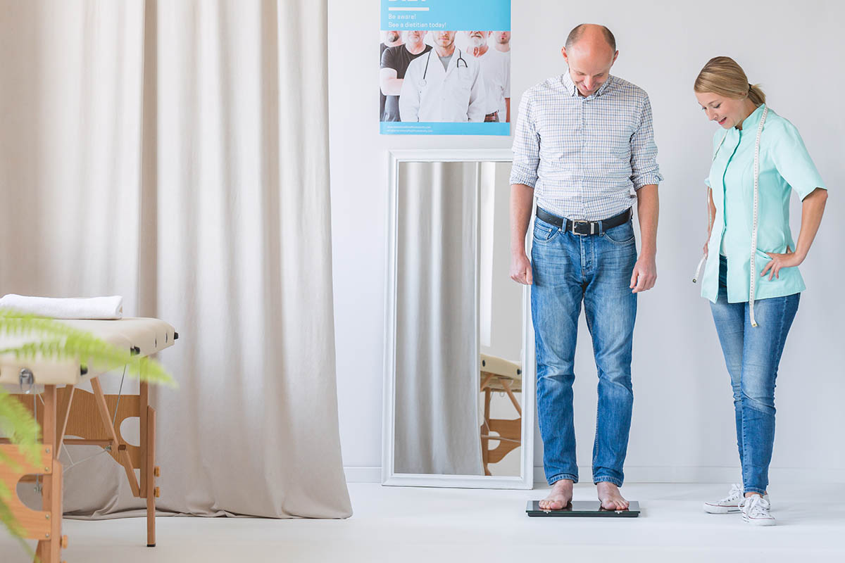 Middle age man is standing on the scale