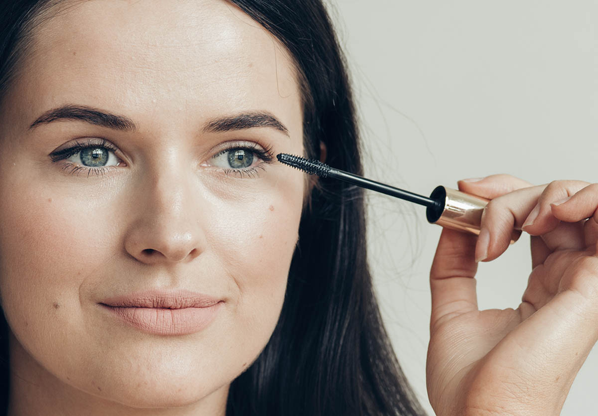 Woman applies eye makeup